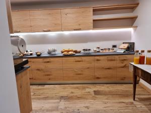 una cocina con armarios de madera y platos de comida en La Culla B&B, en Padola