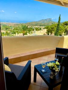 balcone con tavolo e 2 bicchieri di vino di La Manga Club Beautiful 2 bedroom Villa with community pool a Cartagena