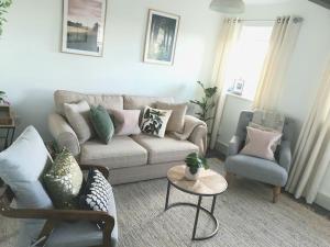 a living room with a couch and two chairs at Romantic & Cosy Cottage with Direct Access to the Hills in Malvern Wells