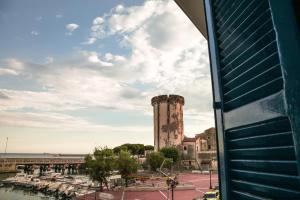 een gebouw met een toren naast een jachthaven met boten bij Filoblu appartamento Formia in Formia
