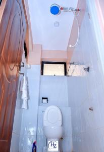 a small bathroom with a toilet and a shower at Hotel Zesper in Kisii