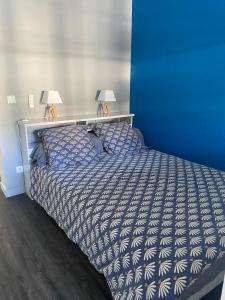 ein blaues Schlafzimmer mit einem Bett mit zwei Lampen in der Unterkunft Fleur de Lys - St Denis Providence GR - ONF in Saint-Denis