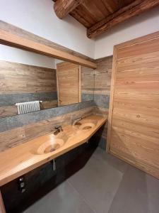 uma casa de banho com um lavatório e armários de madeira em Chalet allemand em Sauze dʼOulx