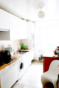uma cozinha com armários brancos e uma máquina de lavar roupa em Heart of Paris - Entire or Private Room Apartment - Bastille & Marais em Paris
