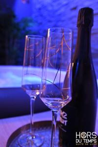 due bicchieri di vino seduti accanto a una bottiglia di vino di Hors du Temps ad Aywaille