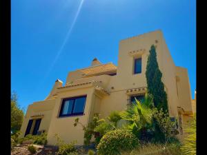 una grande casa bianca con un cielo blu sullo sfondo di La Manga Club Beautiful 2 bedroom Villa with community pool a Cartagena