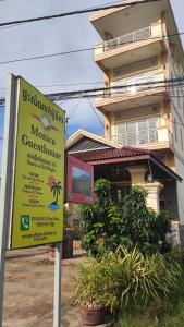 una señal frente a una casa con un edificio en Monica Guesthouse en Kampot