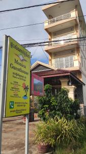 ein Schild vor einem Haus mit einem Gebäude in der Unterkunft Monica Guesthouse in Kampot