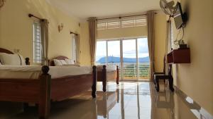 a bedroom with two beds and a large window at Monica Guesthouse in Kampot
