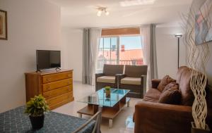 sala de estar con sofá y TV en Apartamentos Ambitus Active, en Sanxenxo