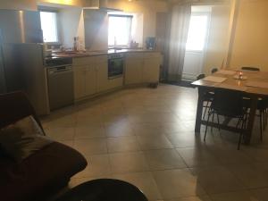 a kitchen with a table and a couch and a table and a kitchen with at Petite maison de campagne in Recey-sur-Ource