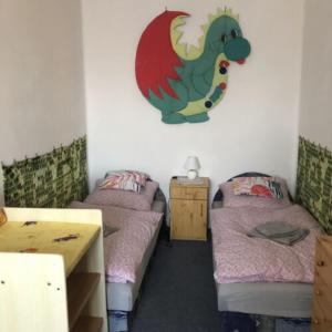 a room with two beds and a dragon on the wall at István Apartman in Tiszafüred