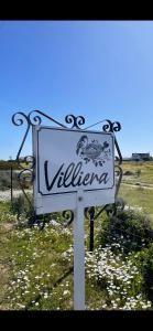 a white sign in a field of flowers at Villiera Guest Farm in Langebaan