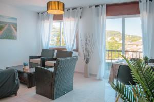 ein Wohnzimmer mit Stühlen und einem großen Fenster in der Unterkunft Apartamentos Ambitus Active in Sanxenxo