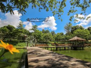 un puente de madera sobre un cuerpo de agua en Norn Nab Dao RimPhu Resort, en Chiang Khan