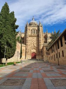 un gran edificio de piedra con puerta roja en Villa Toston City en Salamanca