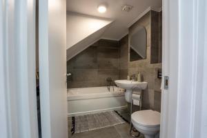 e bagno con lavandino, servizi igienici e vasca. di Marko’s apartament a Sighişoara Altre 9 foto