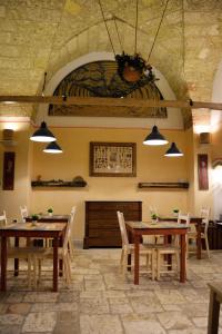 een eetkamer met houten tafels en stoelen bij B&B Palazzo la Traja in Gagliano del Capo