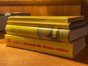 four books stacked on top of each other on a table at Honolulu Hotel in Bregenz