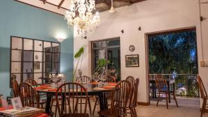 een eetkamer met een tafel en stoelen en een kroonluchter bij Maison 557 in Siem Reap