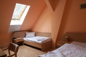 a small room with two beds and a window at Hotel Aeroplan in Zielona Góra