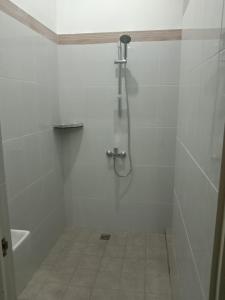 a white bathroom with a shower and a tiled floor at Ida´s House- Holiday Home in Midang