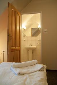 a bathroom with a sink and a bed with towels at Hotel Aeroplan in Zielona Góra