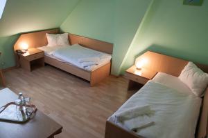 een kleine kamer met 2 bedden en 2 tafels bij Hotel Aeroplan in Zielona Góra