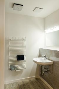 a bathroom with a sink and a towel rack at Strandappartements Steinberghaff "Kegnæs" mit Meerblick und Sauna in Steinberg