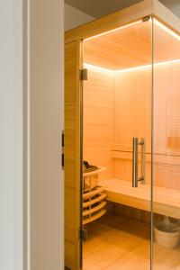 a bathroom with a sauna with a glass door at Strandappartements Steinberghaff "Kegnæs" mit Meerblick und Sauna in Steinberg