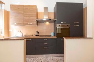 a kitchen with black cabinets and a sink at Angeletti Home in Gassino Torinese