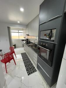 uma cozinha com um fogão e uma mesa em Apartamento Confortável Guarujá no Guarujá