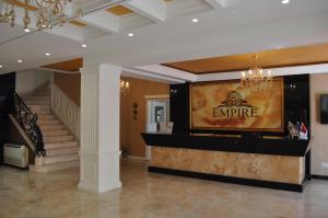 a lobby with a sign that reads empire and a staircase at Hotel Empire Albania in Durrës