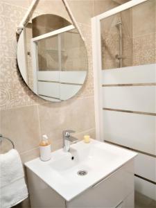 Un baño con un lavabo blanco y un espejo. en Casa Ilda (Gran Alacant), en Gran Alacant