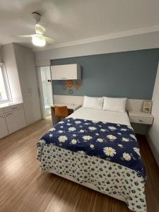 1 dormitorio con 1 cama con pared azul en Apartamento Confortável Guarujá en Guarujá