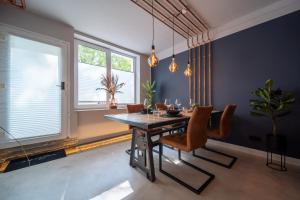 La Bodega - Designer Apartment an der Alster في هامبورغ: غرفة طعام مع طاولة وكراسي خشبية