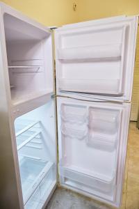 un réfrigérateur vide avec une porte ouverte dans une pièce dans l'établissement The Marlin Rooster Apartments, à Miami