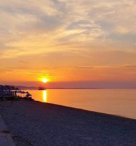 a sunset on the beach with the sun setting at Sunset studio in Pefkohori