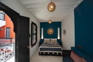 a bedroom with a bed with blue and orange walls at Riad Mylaya in Marrakesh