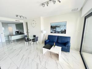 salon z niebieską kanapą i stołem w obiekcie Sunset Drive Resort & Spa w mieście Benidorm