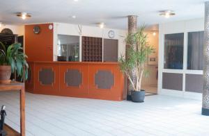 um lobby com uma porta vermelha e algumas plantas em Nadden Hotell & Konferens em Ramnäs