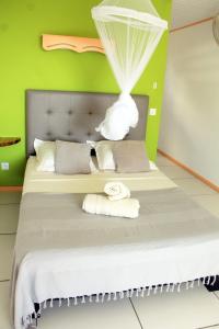 a bedroom with a large bed with green walls at Villa Kajou in Sainte-Anne