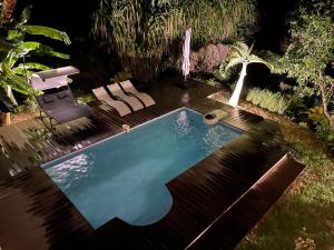 a swimming pool in a backyard at night at Villa Kajou in Sainte-Anne