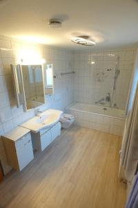een badkamer met een wastafel, een bad en een toilet bij Loisachglück in Garmisch-Partenkirchen