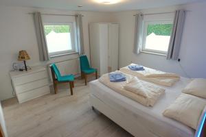1 dormitorio con 1 cama, 2 sillas y 2 ventanas en Loisachglück, en Garmisch-Partenkirchen