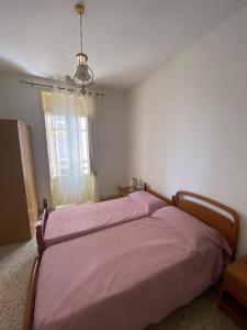 1 dormitorio con 1 cama grande con manta rosa en Casa Vacanza Santa Teresa di Riva, en Santa Teresa di Riva