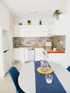 una cocina con armarios blancos y una mesa azul en Casa Ilda (Gran Alacant), en Gran Alacant