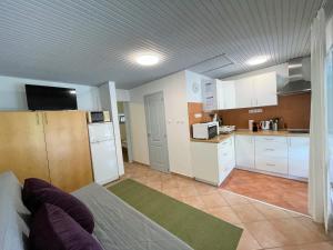 een woonkamer met een bank en een keuken bij Iker Nyaraló Balatonfenyves in Balatonfenyves