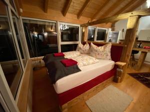 ein kleines Bett in einem Zimmer mit Fenstern in der Unterkunft Atelier mit Bergblick 