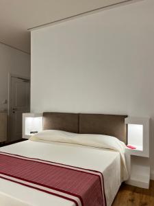 a bedroom with a large white bed with two lights at Dimora Elle in La Maddalena